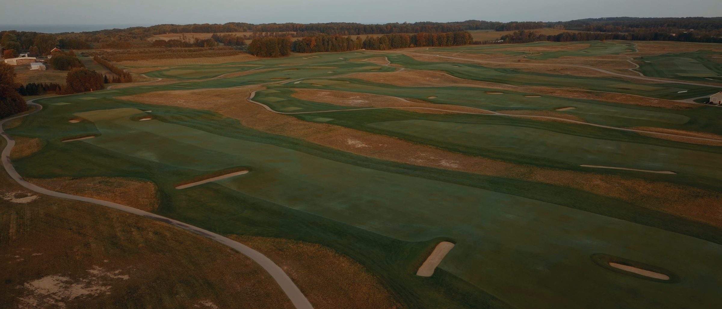 Golf fairway stretching toward a green at sunrise